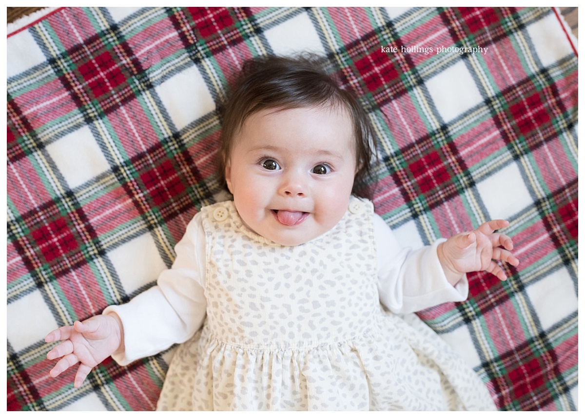 Five month old lies on plaid blanket for holiday photo