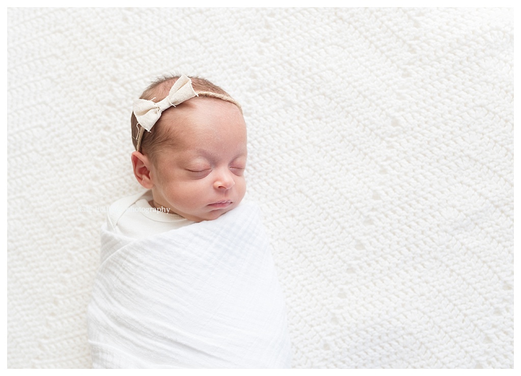 Baby girl is wrapped in white for her photograph