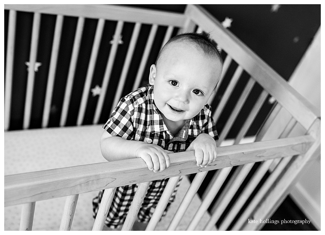 One year old stands in his crib