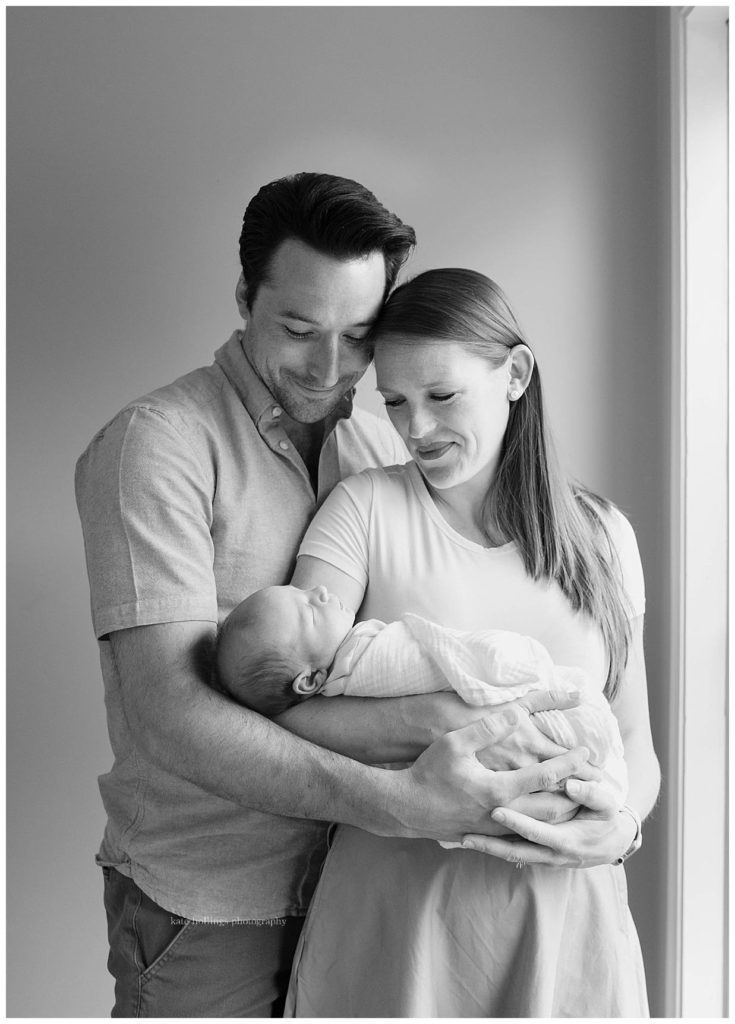black and white image of newborn with parents
